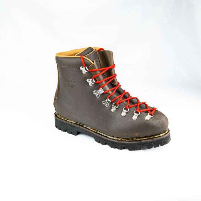 Chaussure de montagne iconique Galibier Super Guide en cuir marron avec lacets rouges contrastants et semelle crantée imposante.