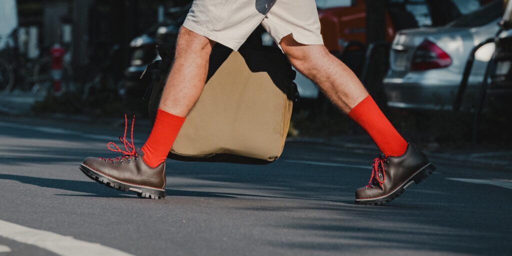 Homme portant des chaussures de marche urbaine Galibier en cuir marron avec semelles Vibram sur le macadam en ville.