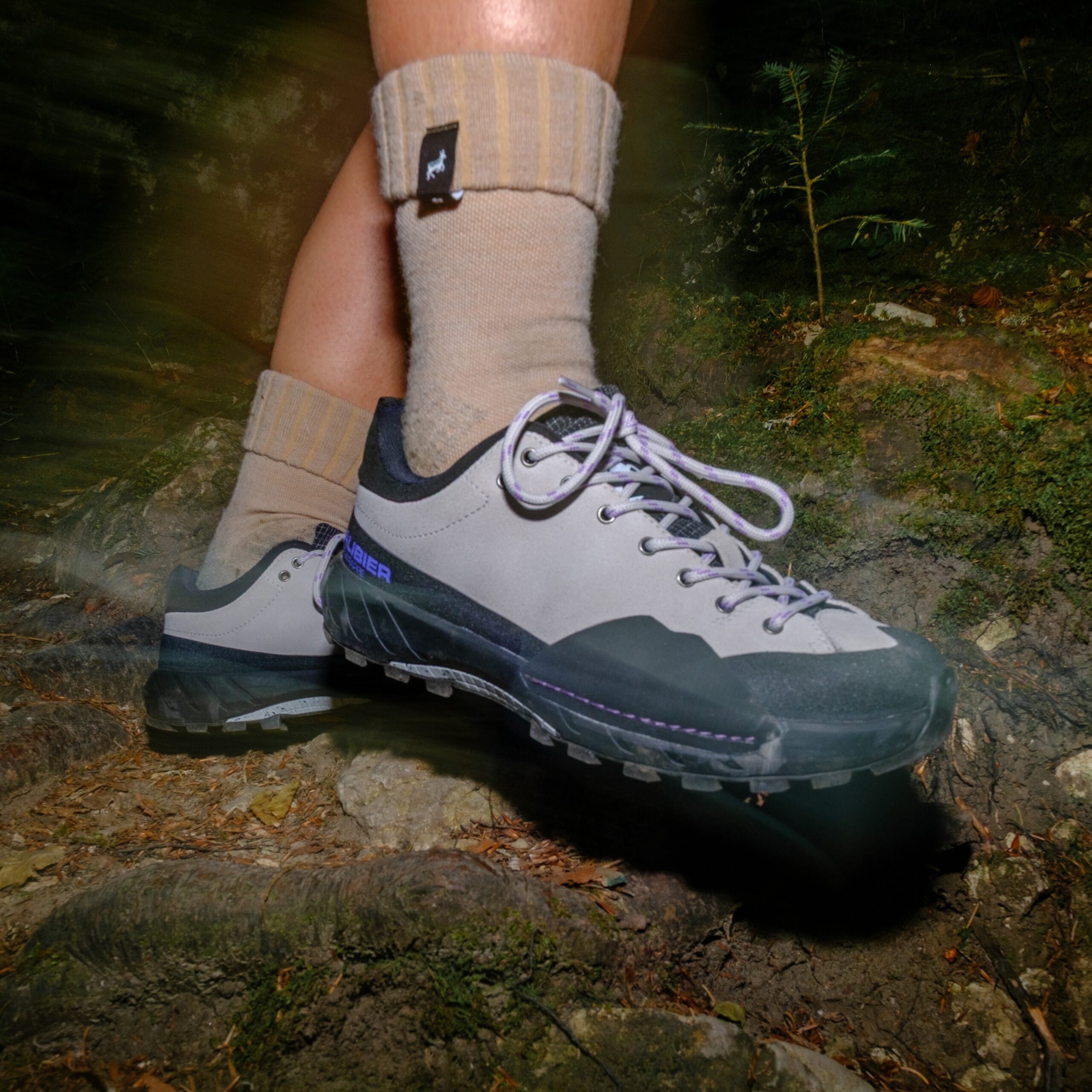 Paire de chaussures fast hiking femme Galibier Super Varappe Low grises et violettes sur un sol de racines.