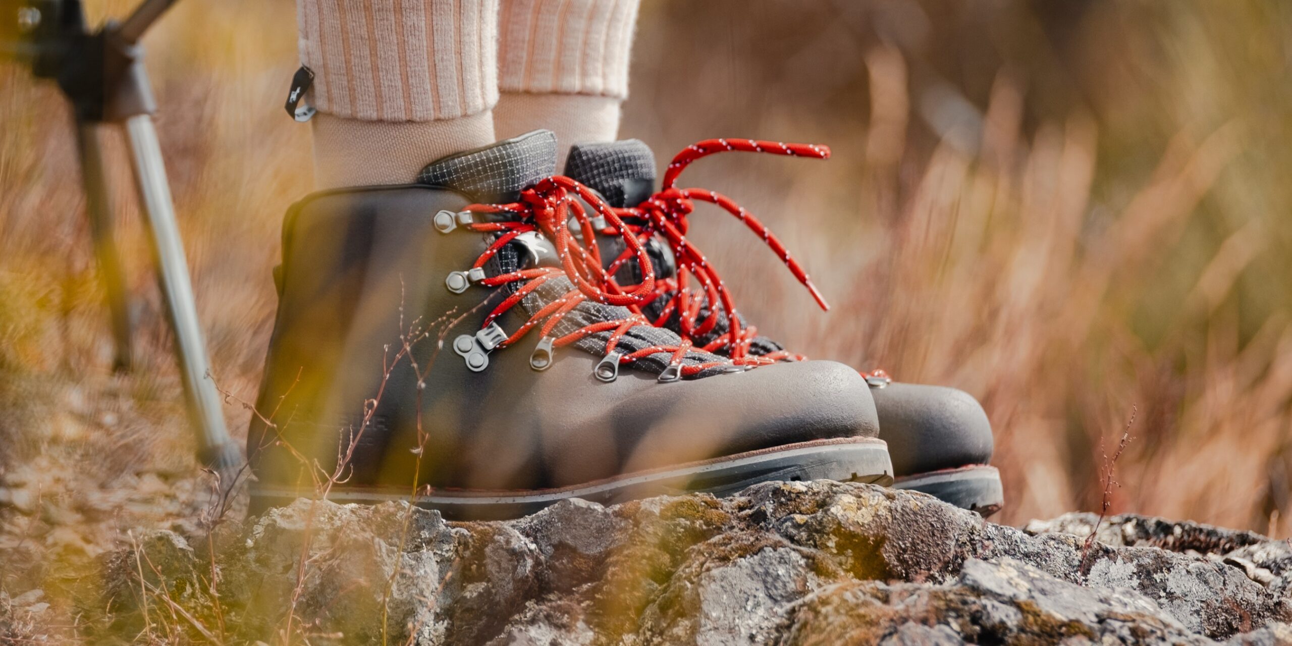 Gros plan de profil de chaussures de randonnée en cuir marron Galibier avec lacets rouges iconiques sur un rocher. Sport de plein air