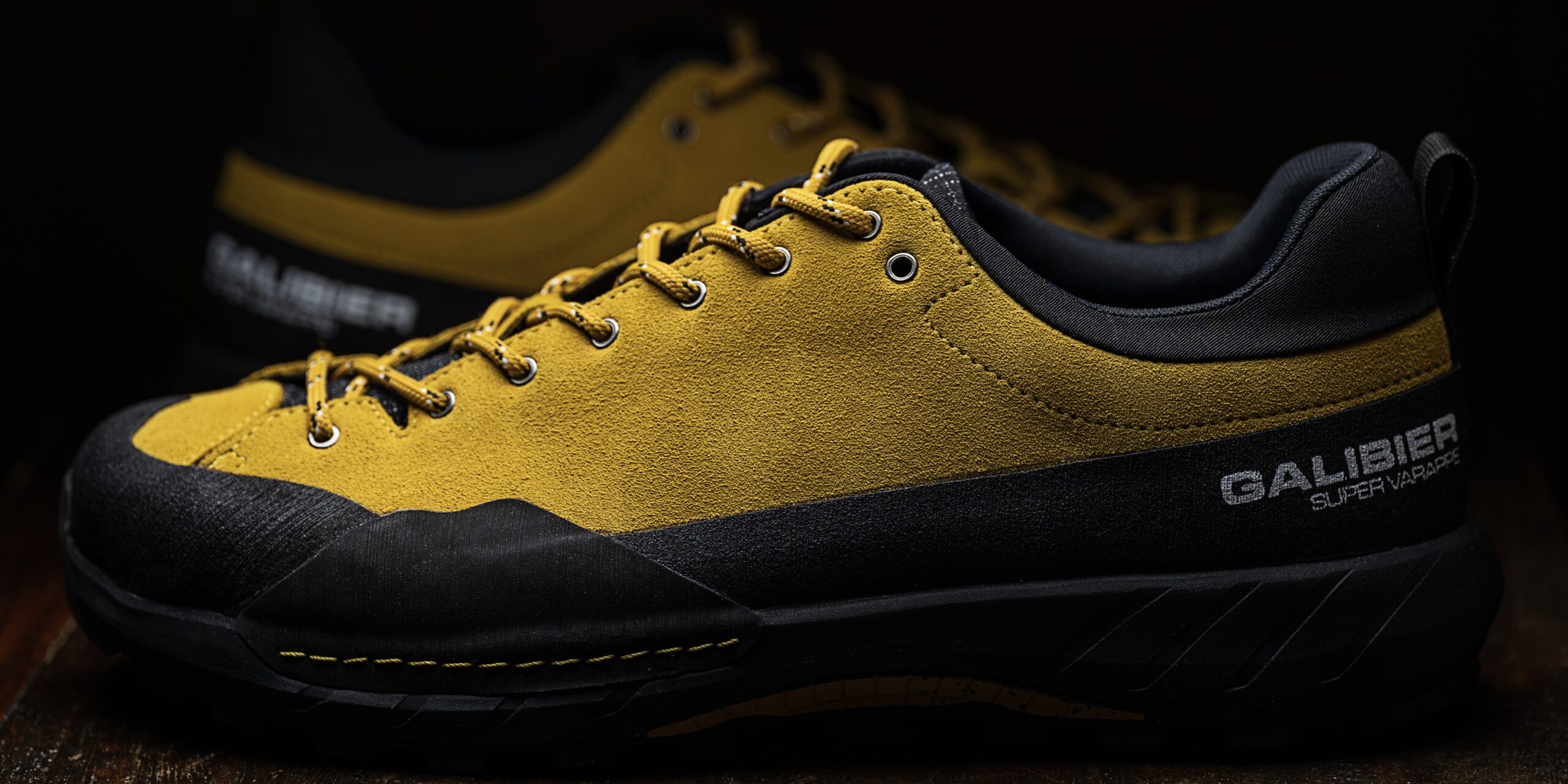 Profil d'une chaussure outdoor homme basse Galibier Super Varappe en cuir suédé jaune sur fond sombre.