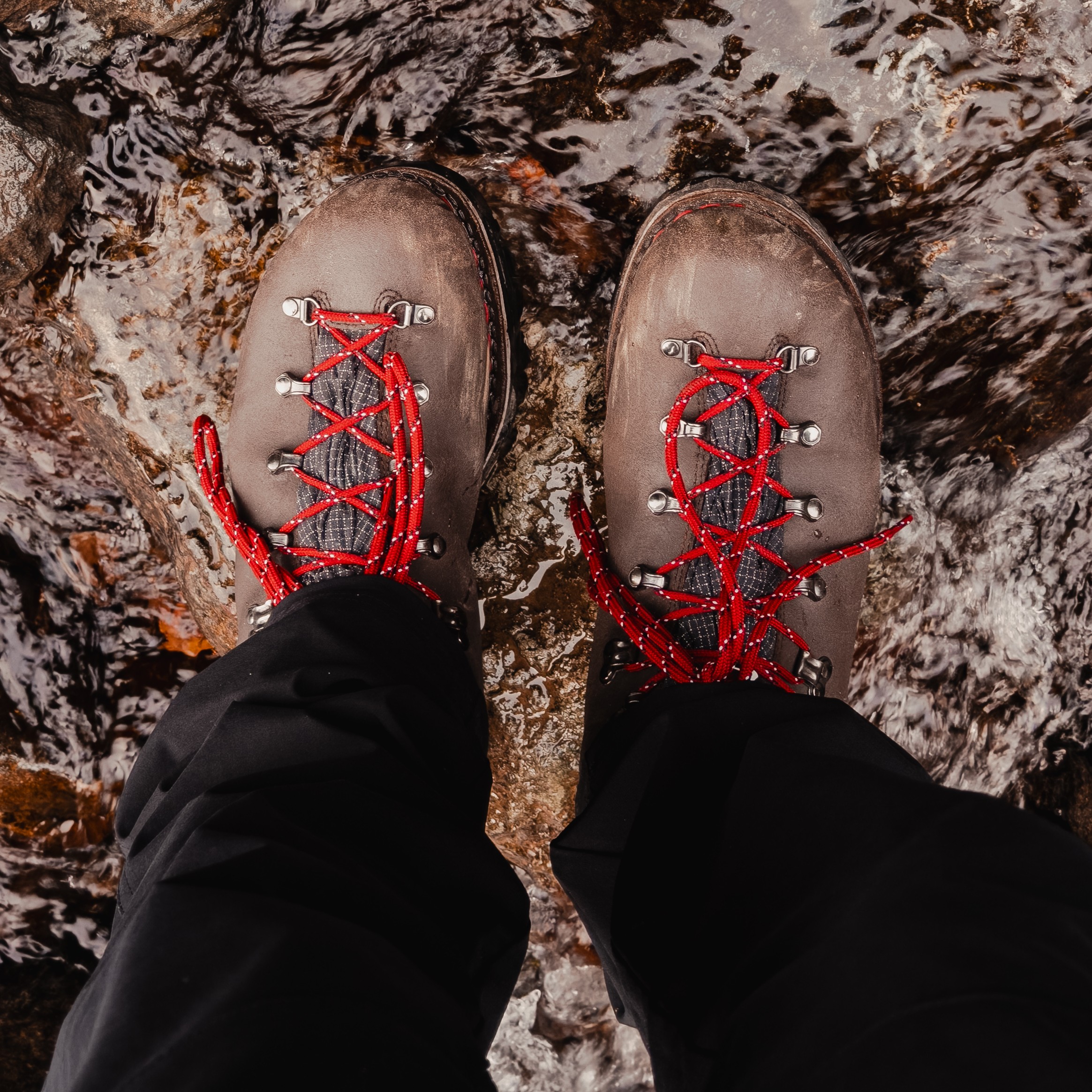 Vue plongeante de chaussures montantes homme outdoor Galibier Super Rando Mid stables sur une roche humide traversée par un cours d'eau. Sport de plein air