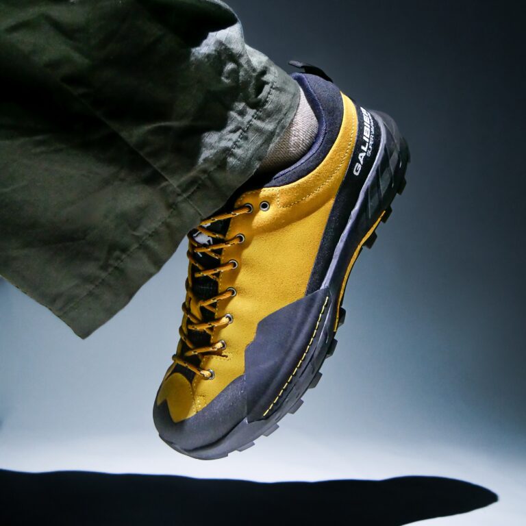 Vue rapprochée d'une chaussure outdoor homme tige basse Galibier Super Varappe Low en cuir suédé jaune moutarde et pare-pierres noir.