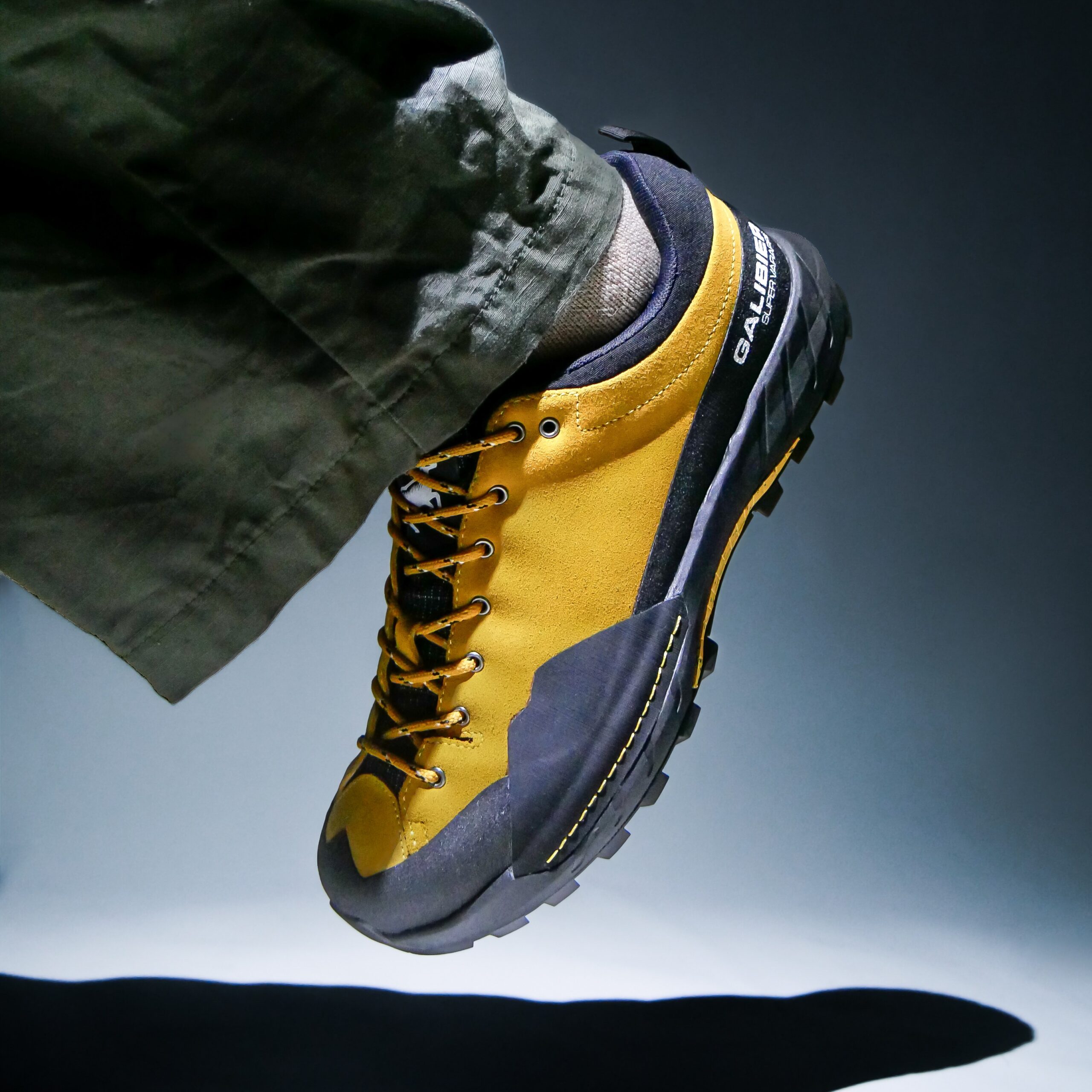Vue rapprochée d'une chaussure outdoor homme tige basse Galibier Super Varappe Low en cuir suédé jaune moutarde et pare-pierres noir.